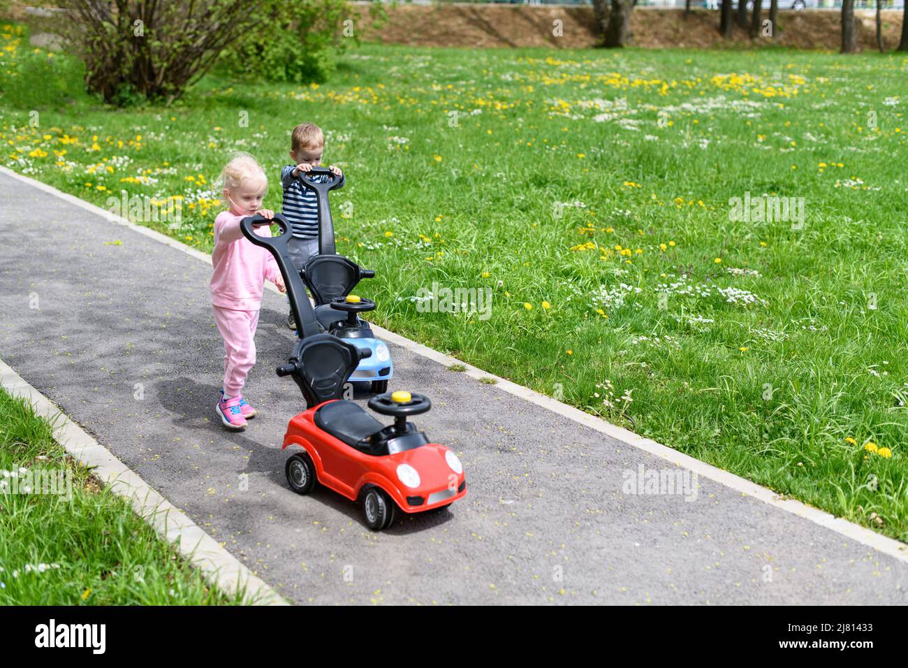 Kids Are Playing With a Toy Car Outdoors in the Park - A Happy Boy and ...
