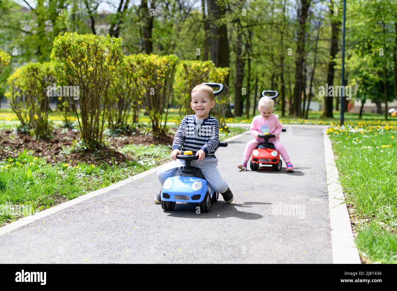 Kids Are Playing With a Toy Car Outdoors in the Park - A Happy Boy and ...