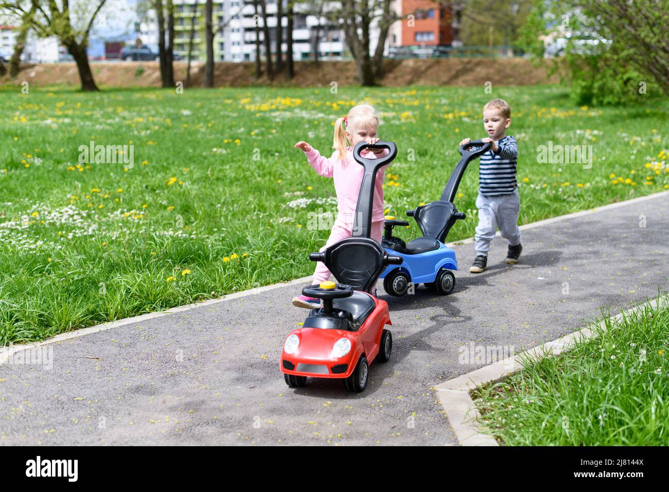 Kids Are Playing With a Toy Car Outdoors in the Park - A Happy Boy and ...