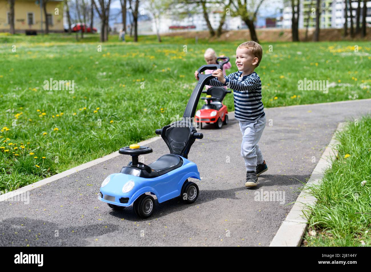Kids Are Playing With a Toy Car Outdoors in the Park - A Happy Boy and ...