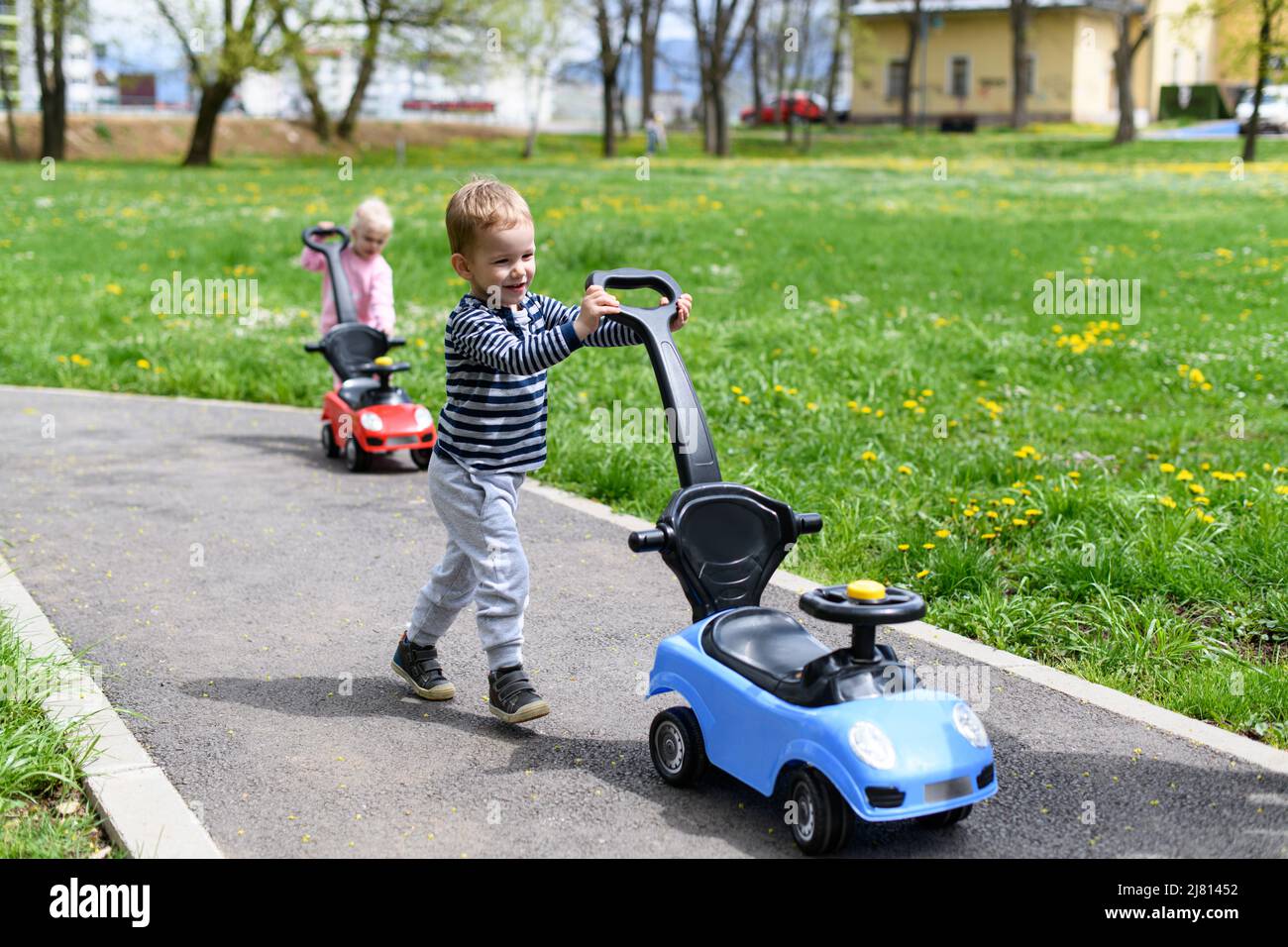 Kids Are Playing With a Toy Car Outdoors in the Park - A Happy Boy and ...