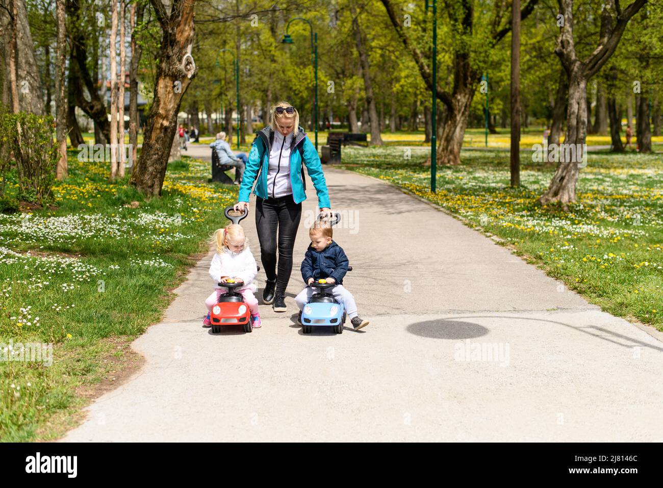 Mom and Kids Are Playing With a Toy Car Outdoors in the Park - A Happy ...