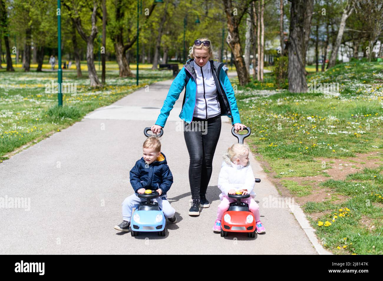 Mom and Kids Are Playing With a Toy Car Outdoors in the Park - A Happy ...