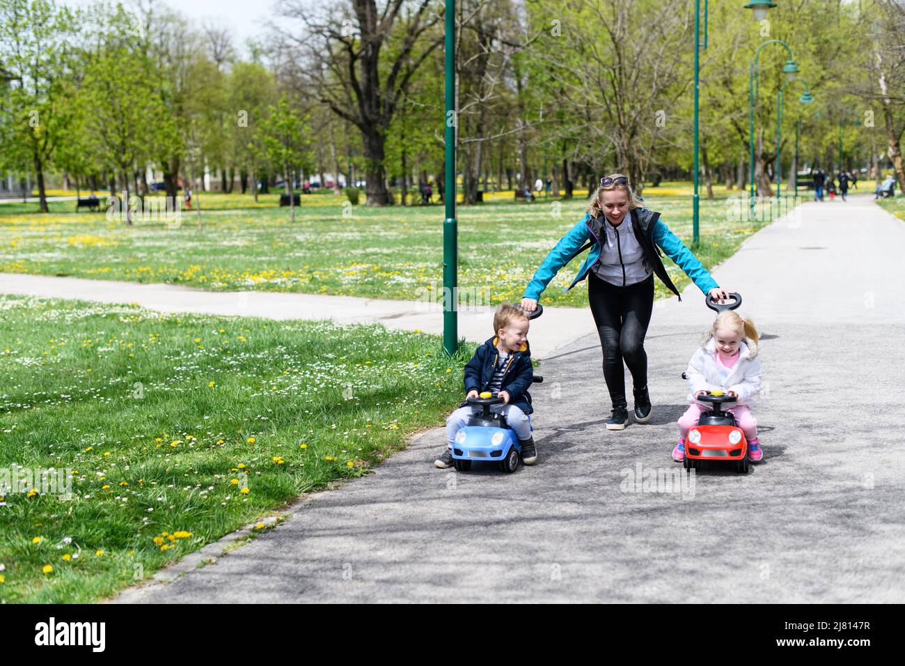Mom and Kids Are Playing With a Toy Car Outdoors in the Park - A Happy ...