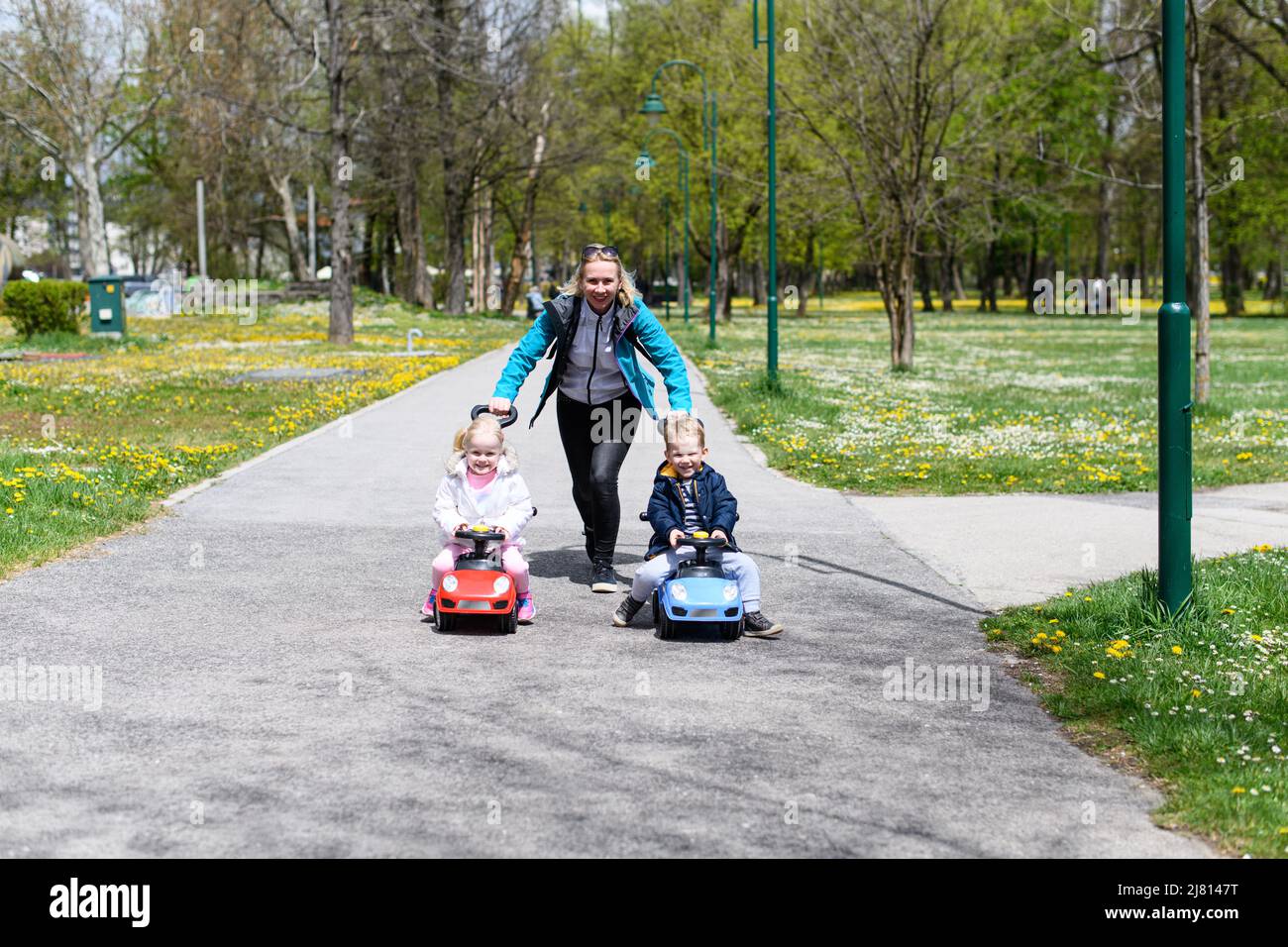 Mom and Kids Are Playing With a Toy Car Outdoors in the Park - A Happy ...