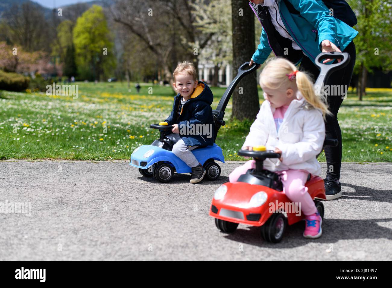 Mom and Kids Are Playing With a Toy Car Outdoors in the Park - A Happy ...