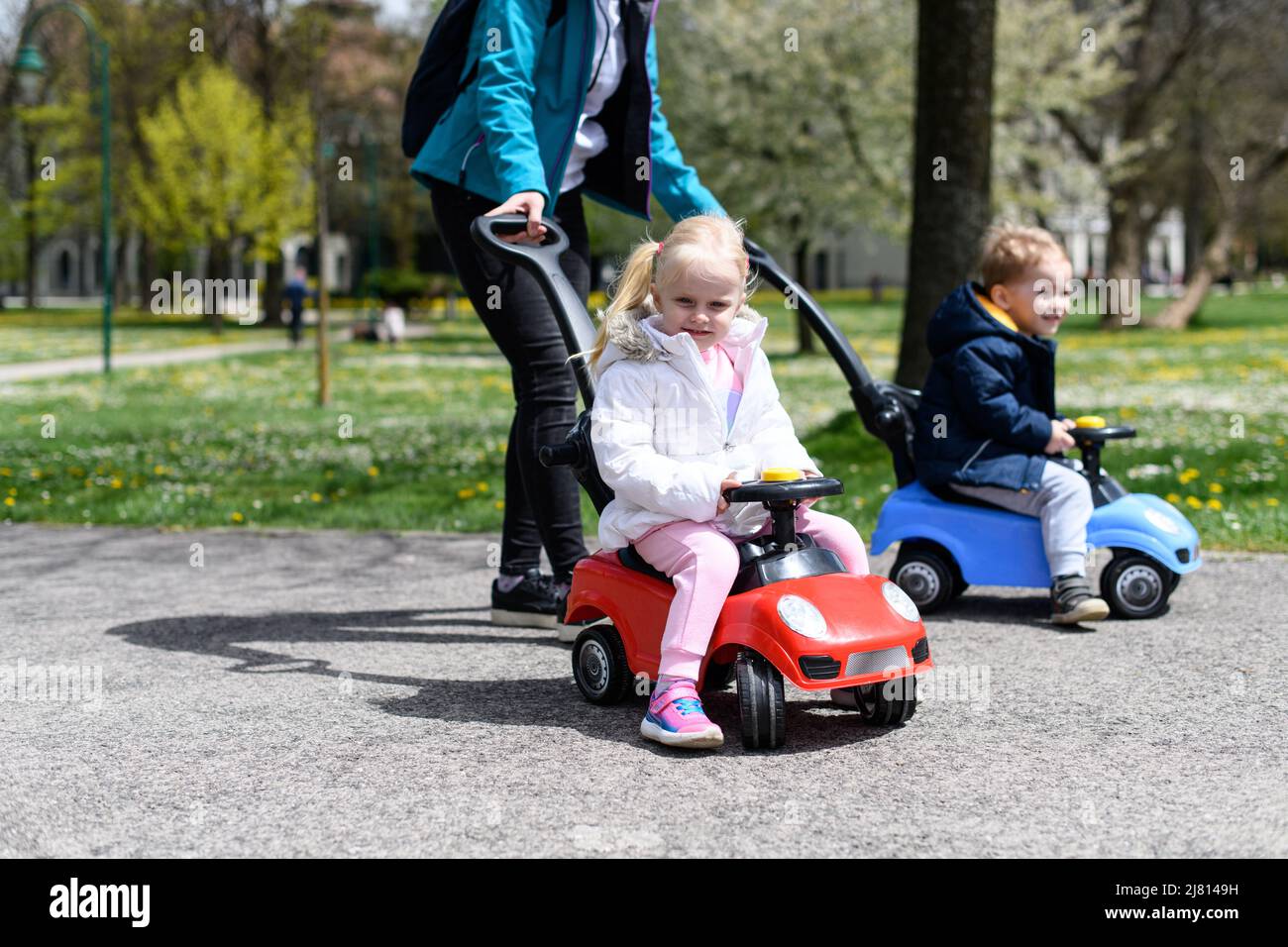 Mom and Kids Are Playing With a Toy Car Outdoors in the Park - A Happy ...