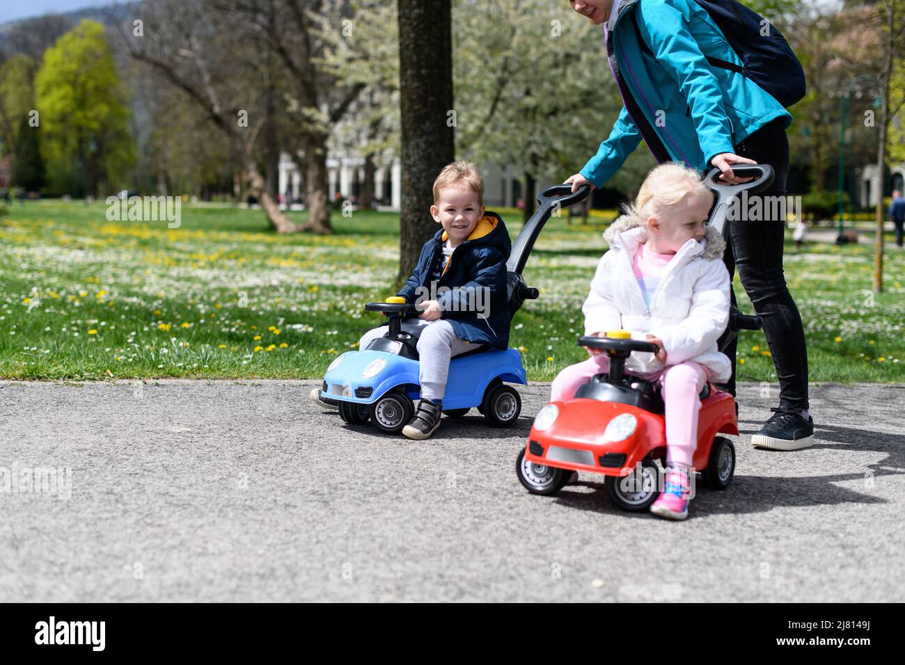 Mom and Kids Are Playing With a Toy Car Outdoors in the Park - A Happy ...