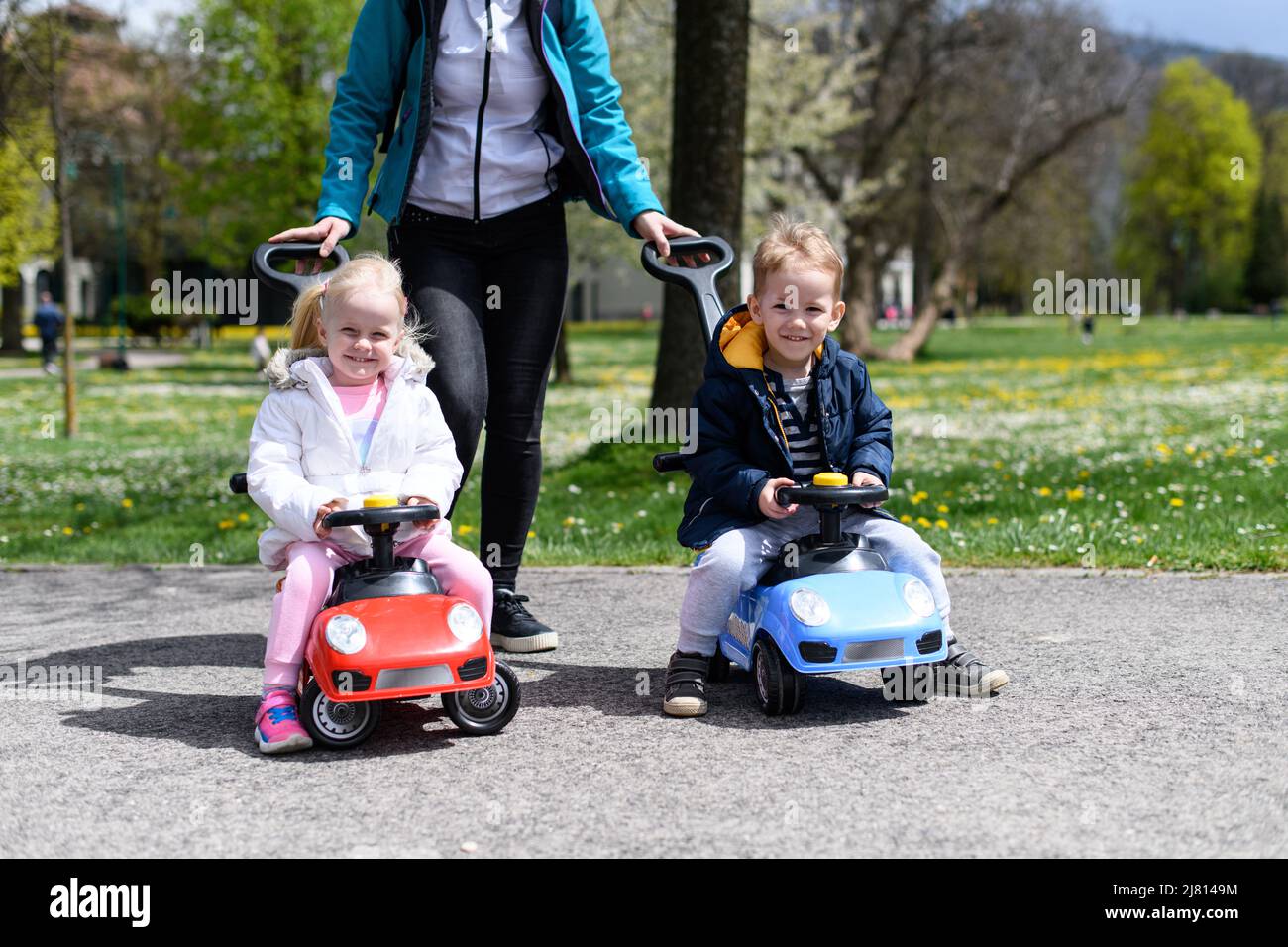 Mom and Kids Are Playing With a Toy Car Outdoors in the Park - A Happy ...