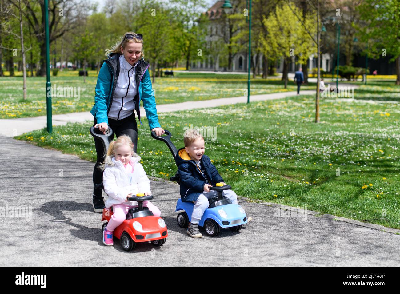 Mom and Kids Are Playing With a Toy Car Outdoors in the Park - A Happy ...