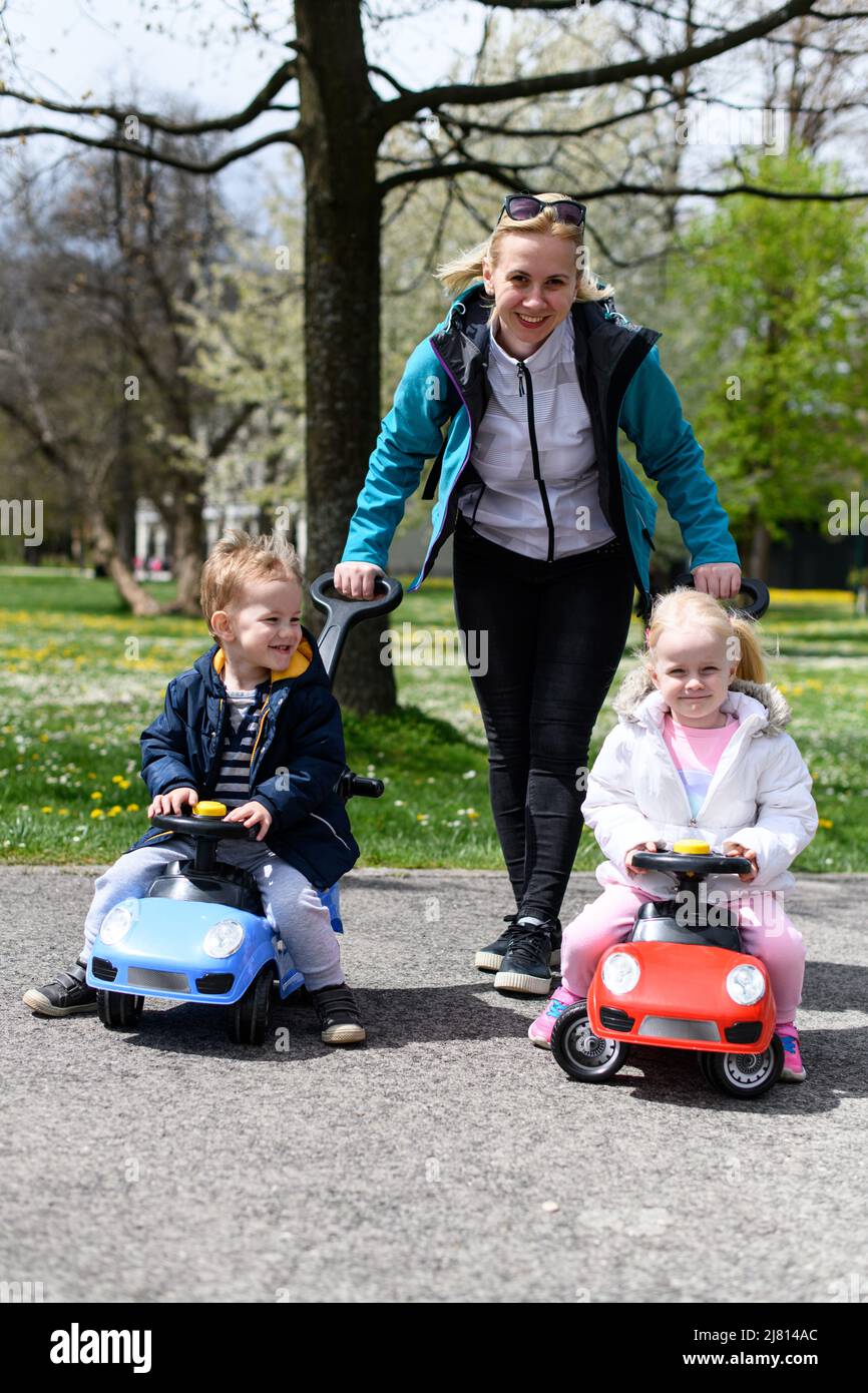 Mom and Kids Are Playing With a Toy Car Outdoors in the Park - A Happy ...