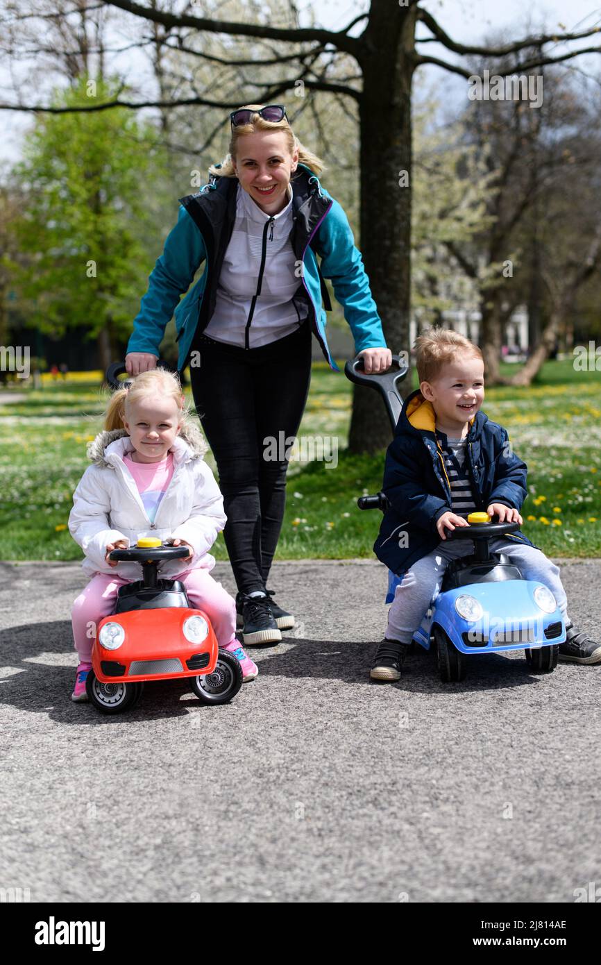 Mom and Kids Are Playing With a Toy Car Outdoors in the Park - A Happy ...