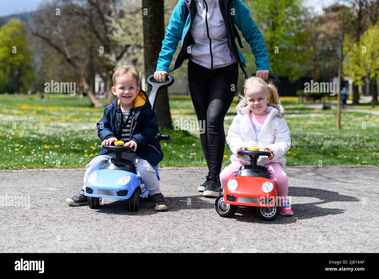 Mom and Kids Are Playing With a Toy Car Outdoors in the Park - A Happy ...
