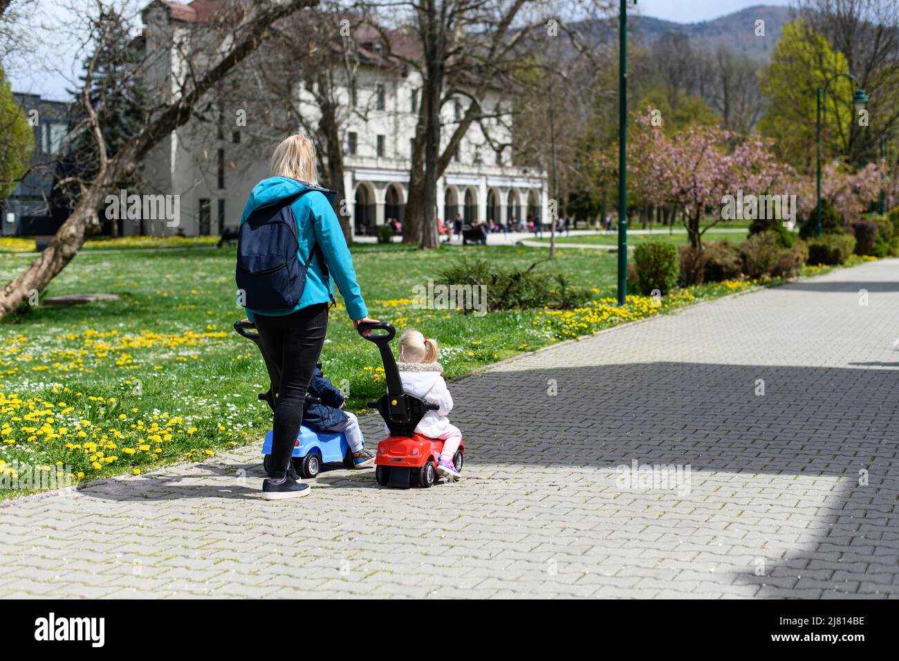 Mom and Kids Are Playing With a Toy Car Outdoors in the Park - A Happy ...