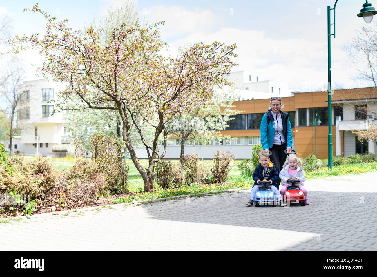 Mom and Kids Are Playing With a Toy Car Outdoors in the Park - A Happy ...