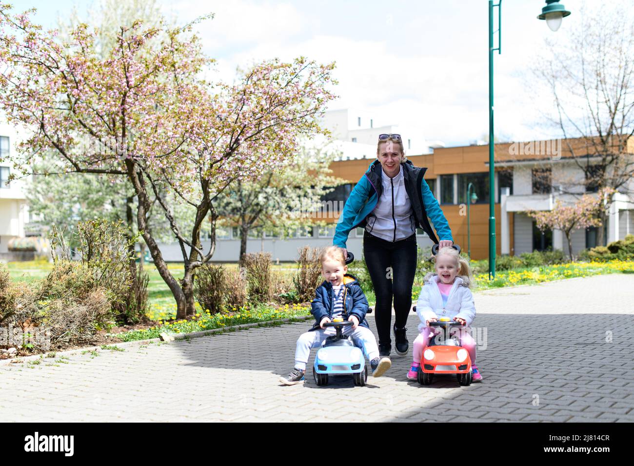 Mom and Kids Are Playing With a Toy Car Outdoors in the Park - A Happy ...