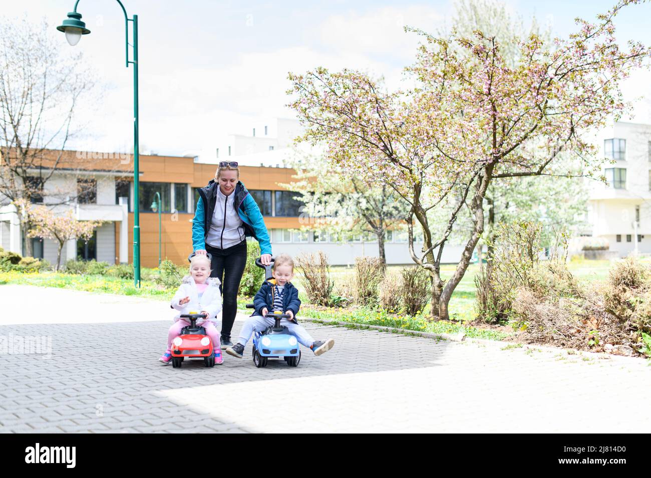 Mom and Kids Are Playing With a Toy Car Outdoors in the Park - A Happy ...