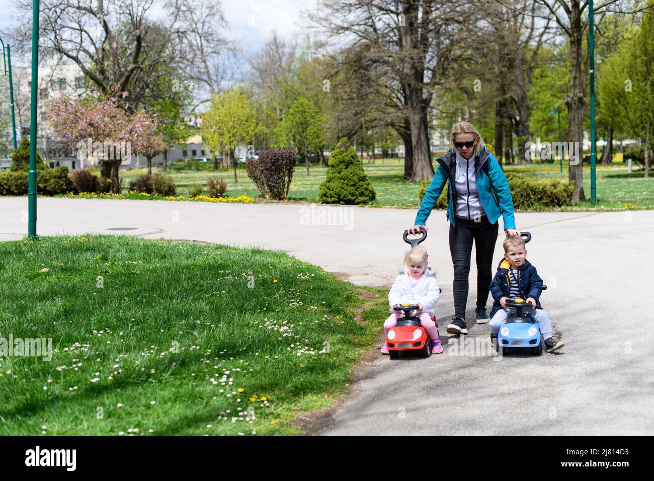 Mom and Kids Are Playing With a Toy Car Outdoors in the Park - A Happy ...