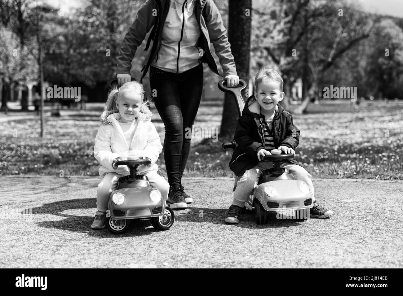 Mom and Kids Are Playing With a Toy Car Outdoors in the Park - A Happy ...