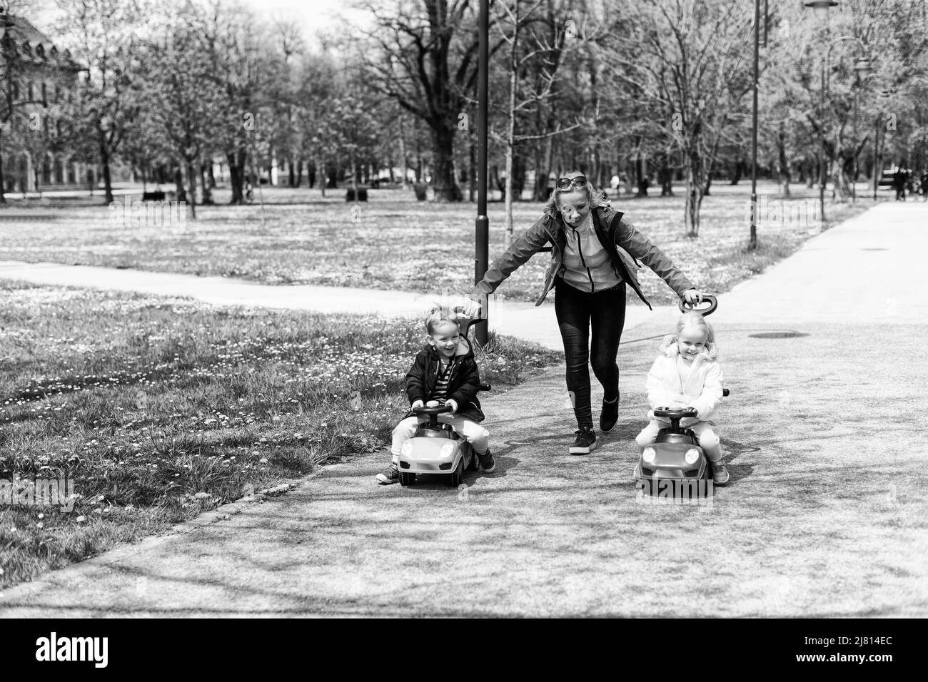 Mom and Kids Are Playing With a Toy Car Outdoors in the Park - A Happy ...