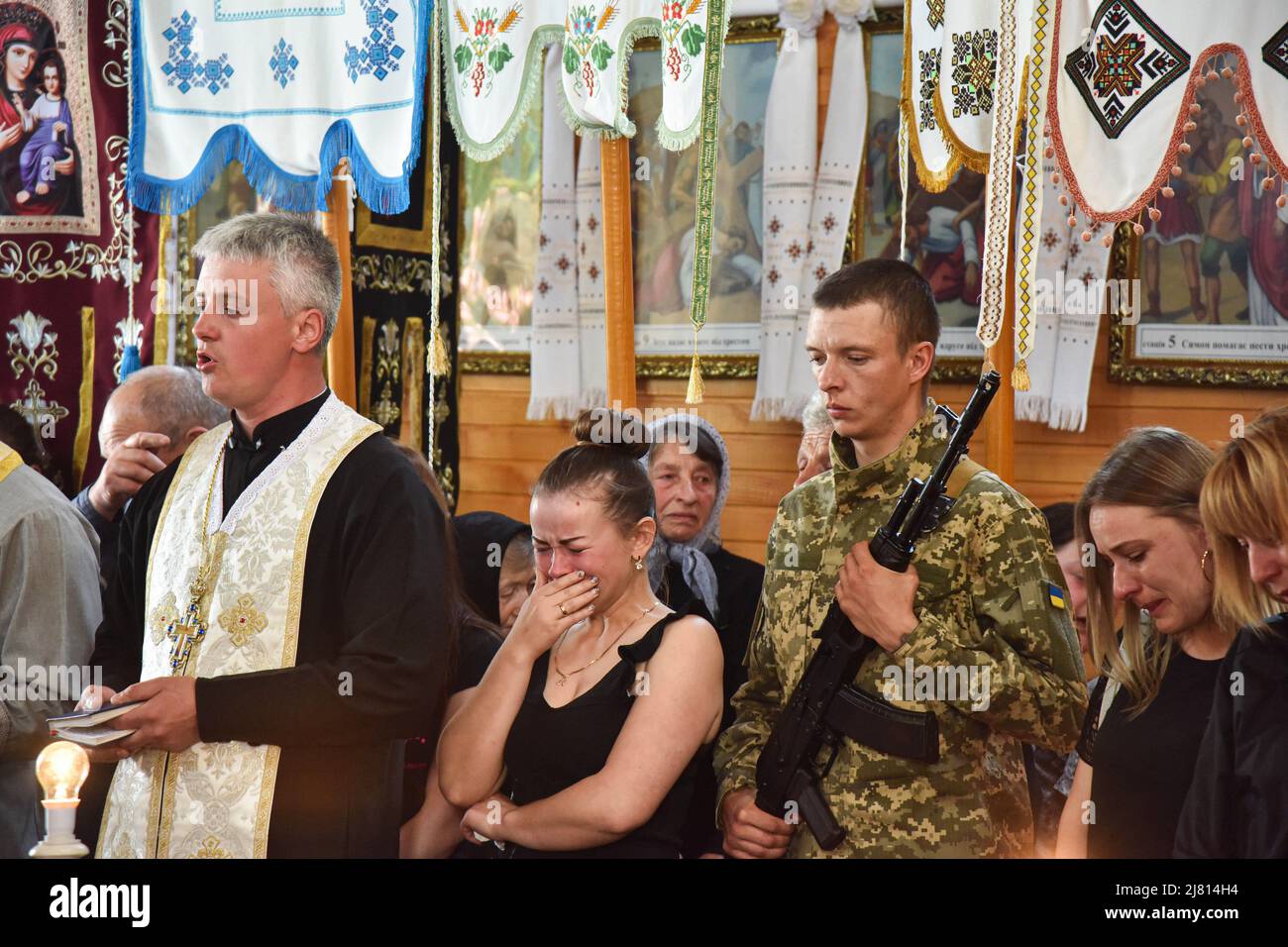 A woman cries in a church at the village of Kulchytsia, Lviv region, during the funeral of senior soldier Petro Sarakulo, who died in the Donetsk region due to Russia's military invasion of Ukraine. Funeral of senior soldier Petro Sarakulo in his native village of Kulchytsi, Lviv region. Due to the Russian military invasion of Ukraine on February 24, 2022, he went to serve in the Armed Forces of Ukraine. He died on May 5 in the Donetsk region during a battle with the Russian occupiers. The deceased is survived by his wife and two children - daughter Milana and son Alexander. (Photo by Pavlo Pa Stock Photo