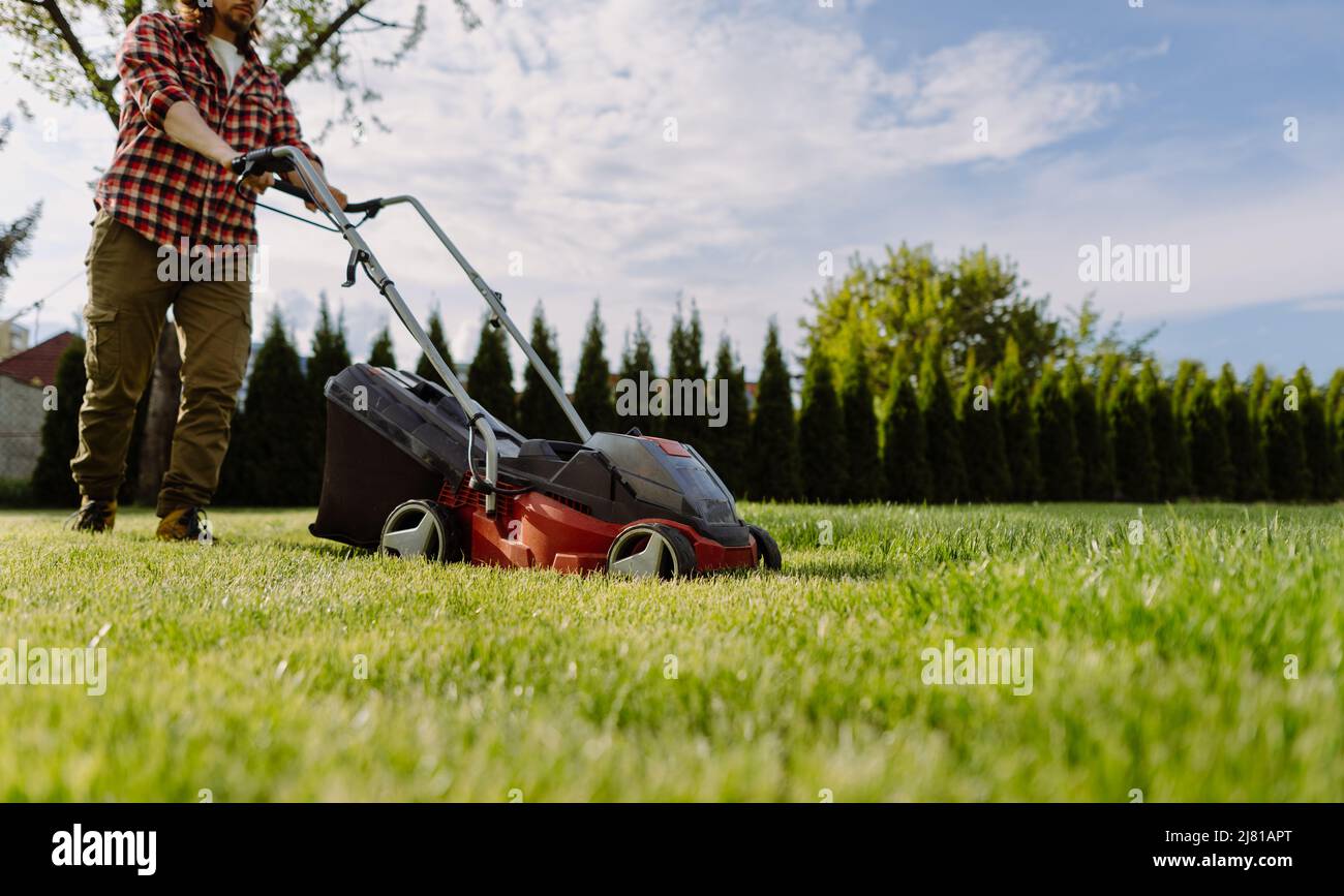 Man mows the lawn at home. Gardening tools concept Stock Photo