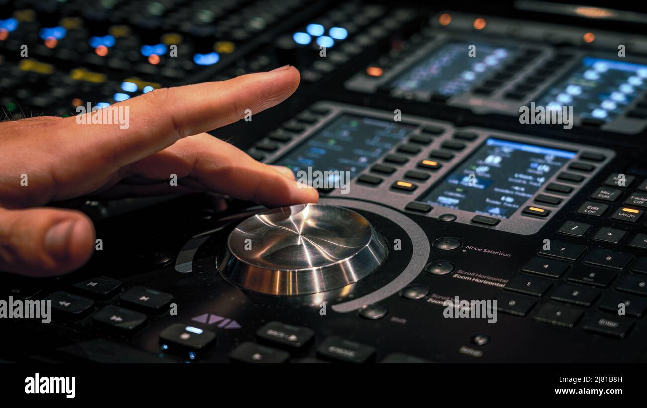 Male hand adjusting the volume on the sound mixing panel Stock Photo