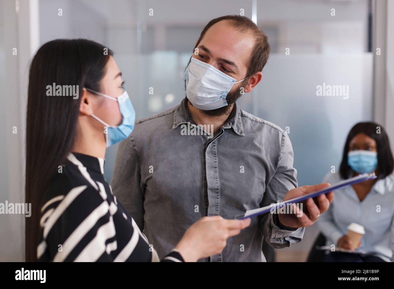 Positive and confident employer wearing protective mask while talking