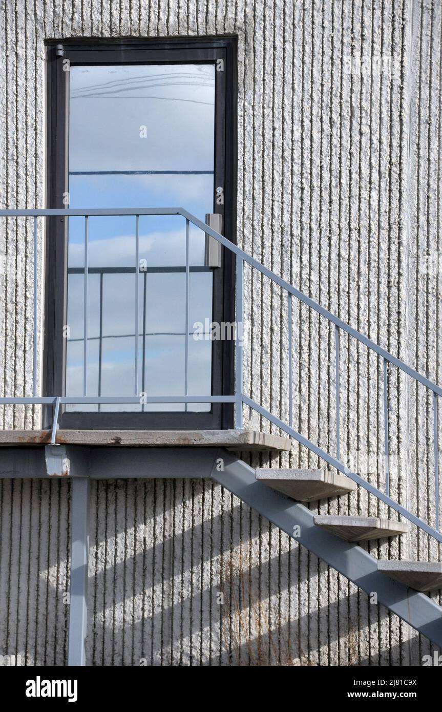 Glass door and wooden stairs with shadows of modern building Stock Photo