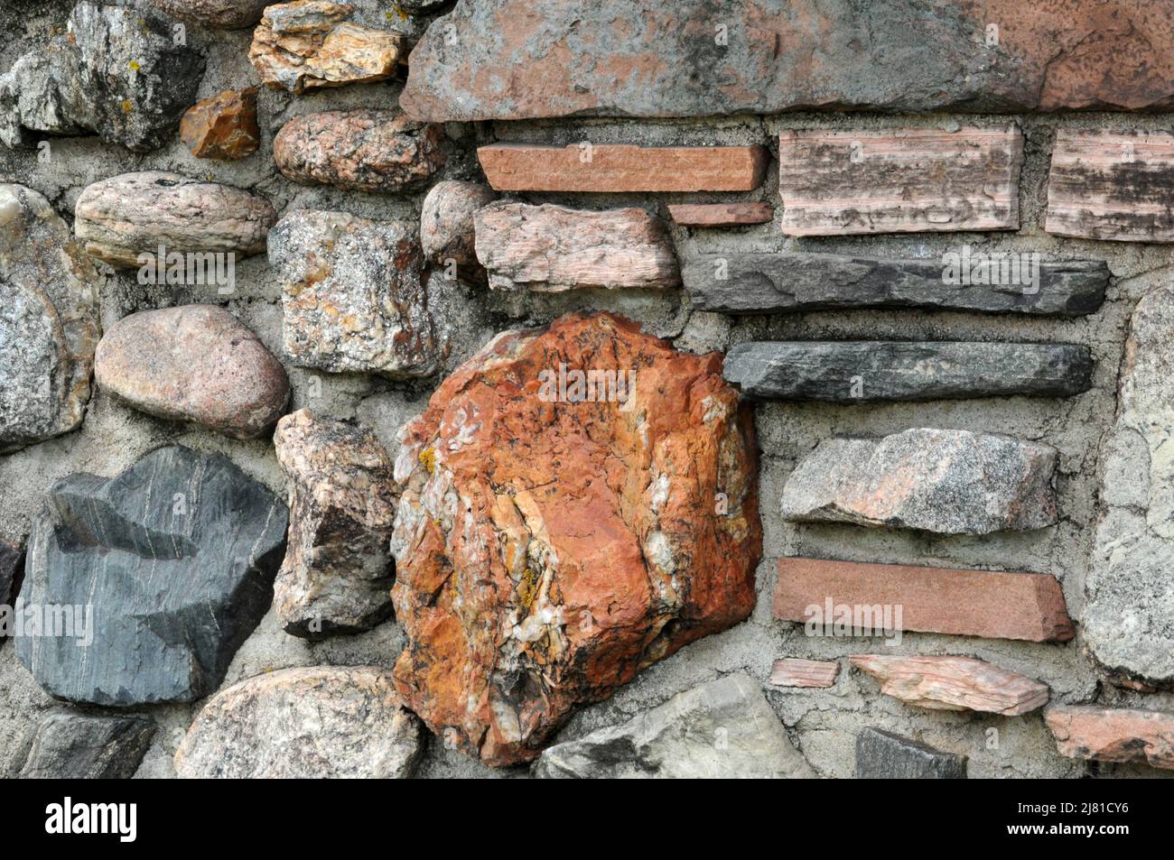 Wall of stone blocks and rocks with mortar closeup background Stock Photo