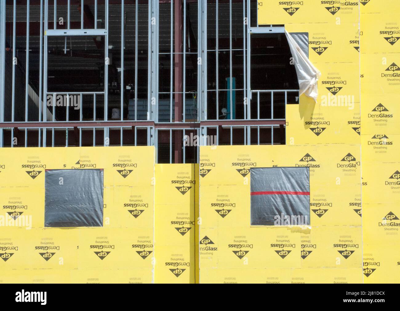 Construction of new building with windows and placement of yellow Georgia-Pacfic Densglass construction sheathing Stock Photo