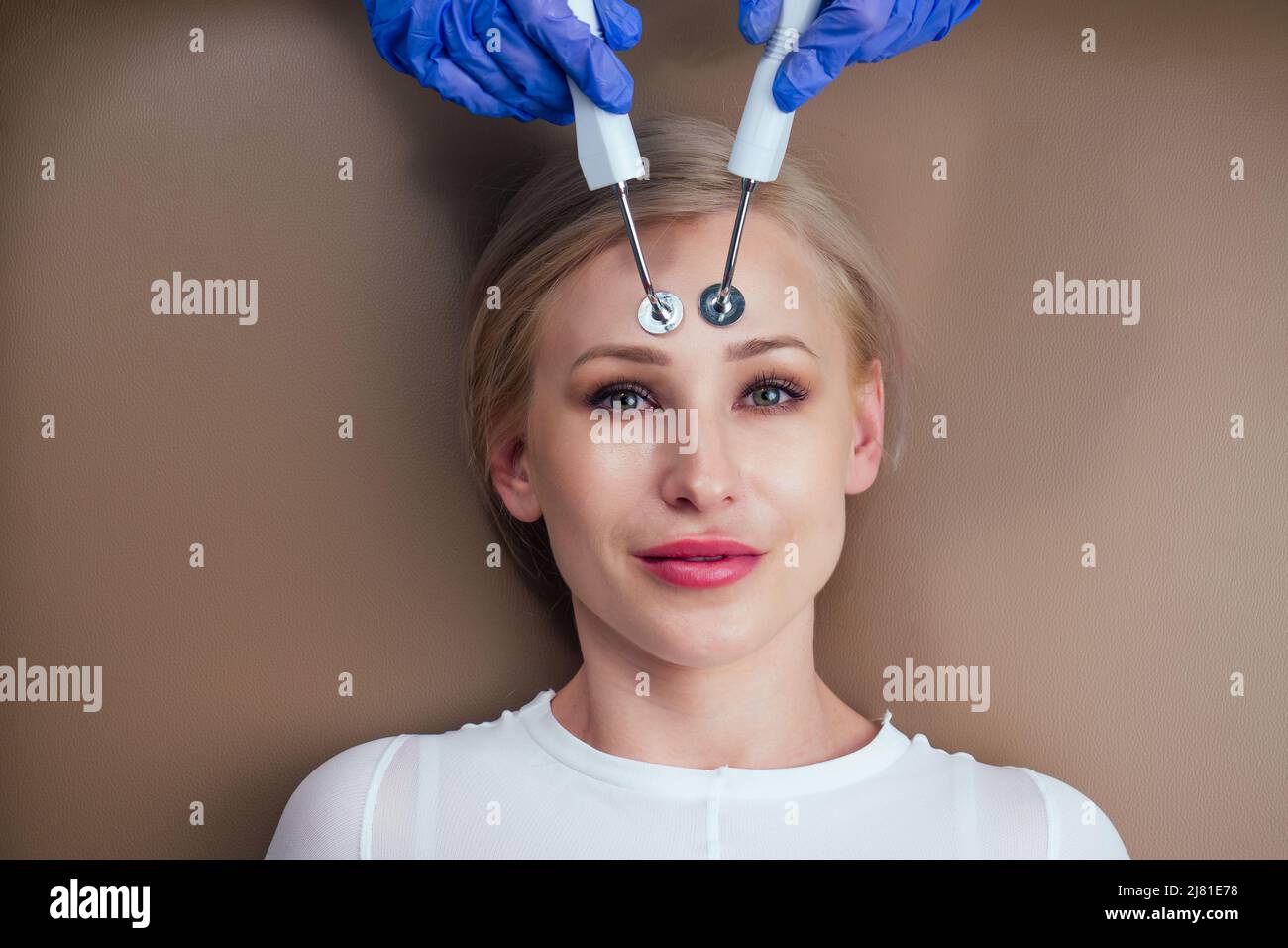 beauty aesthetic spa salon .blonde female getting instrument facial massaging with microcurrent electro instrument device. Stock Photo