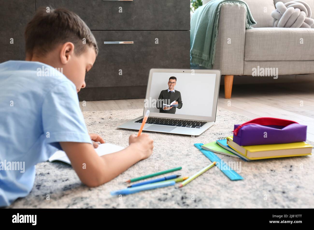 Little boy with laptop studying online at home Stock Photo