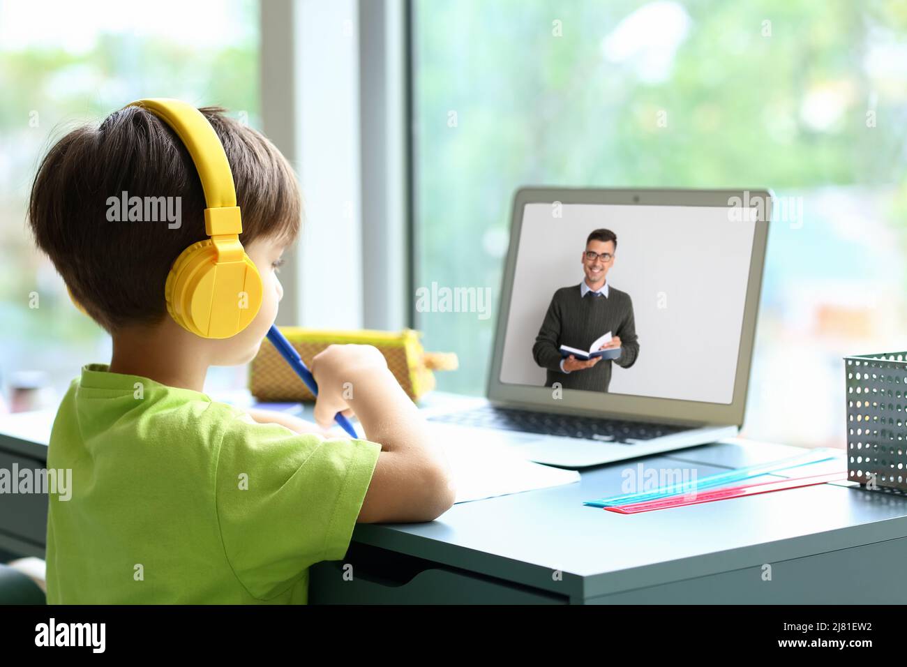 Little schoolboy studying online at home Stock Photo