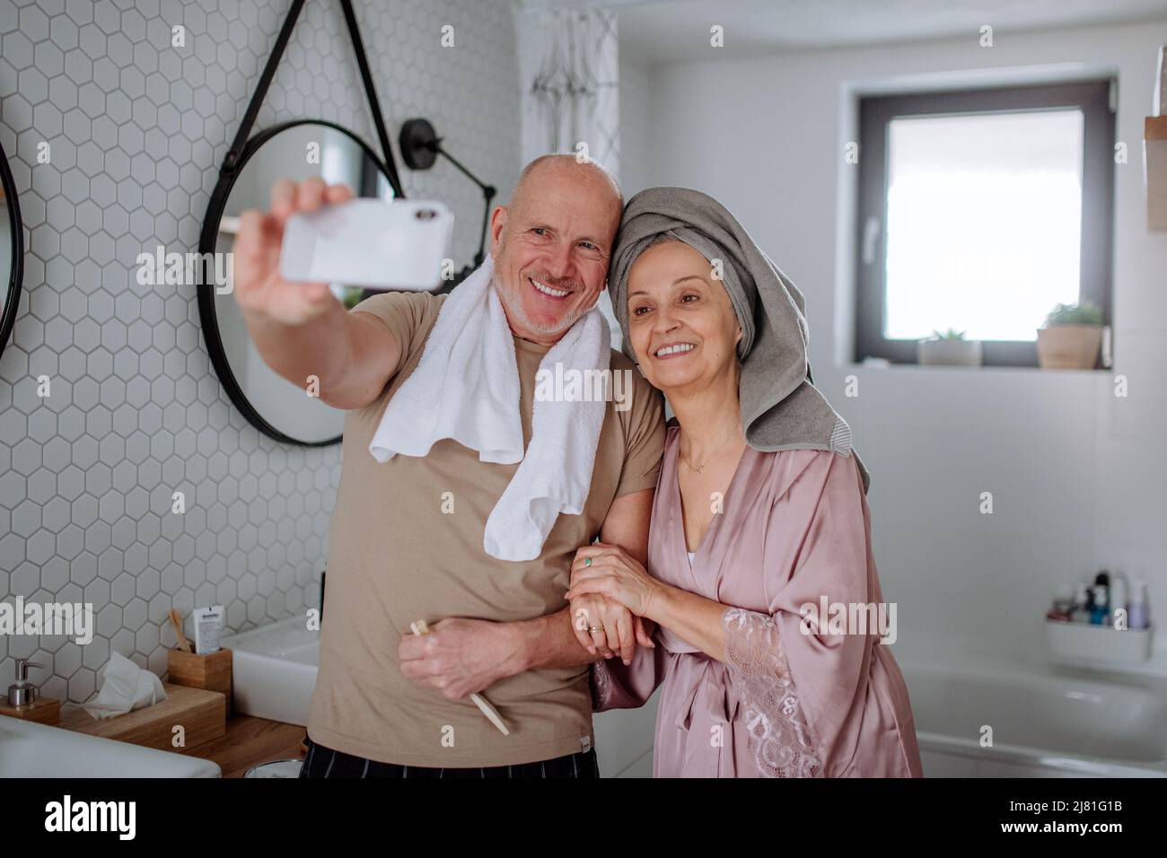 Senior couple in love in bathroom, taking selfie, morning routine ...