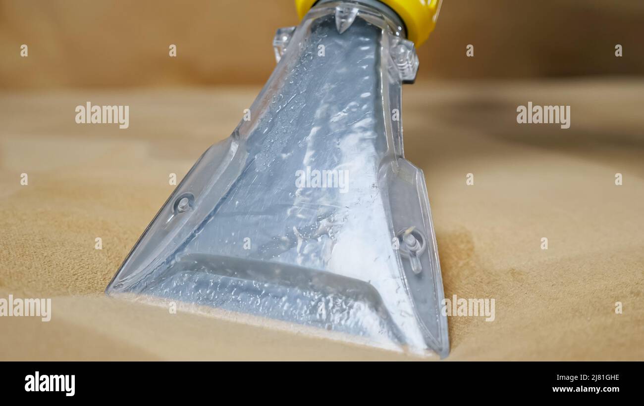 Close up footage of cleaning sofa with vacuum cleaner and detergent