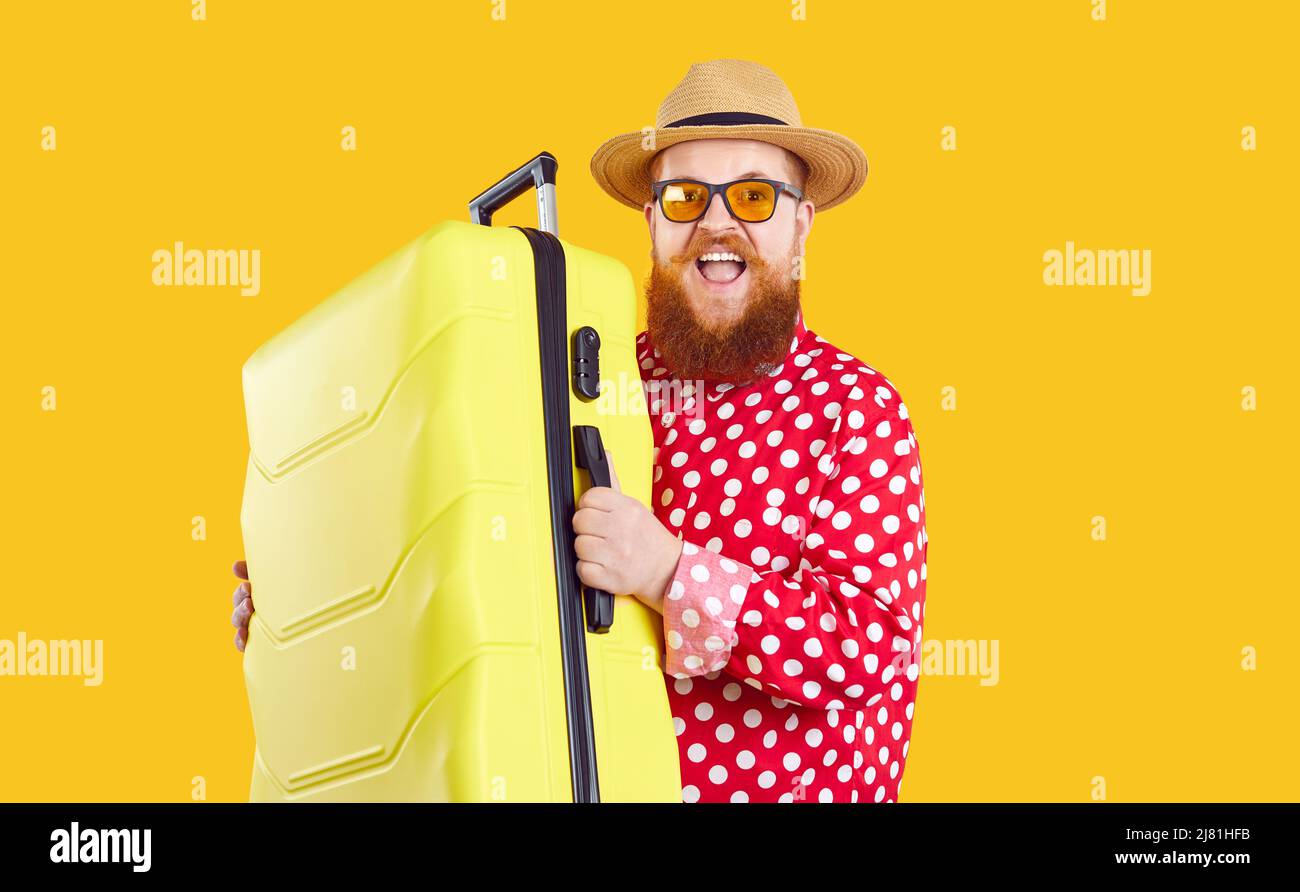 Joyfully funny excited extravagant bearded fat man with suitcase ready for summer vacation. Stock Photo