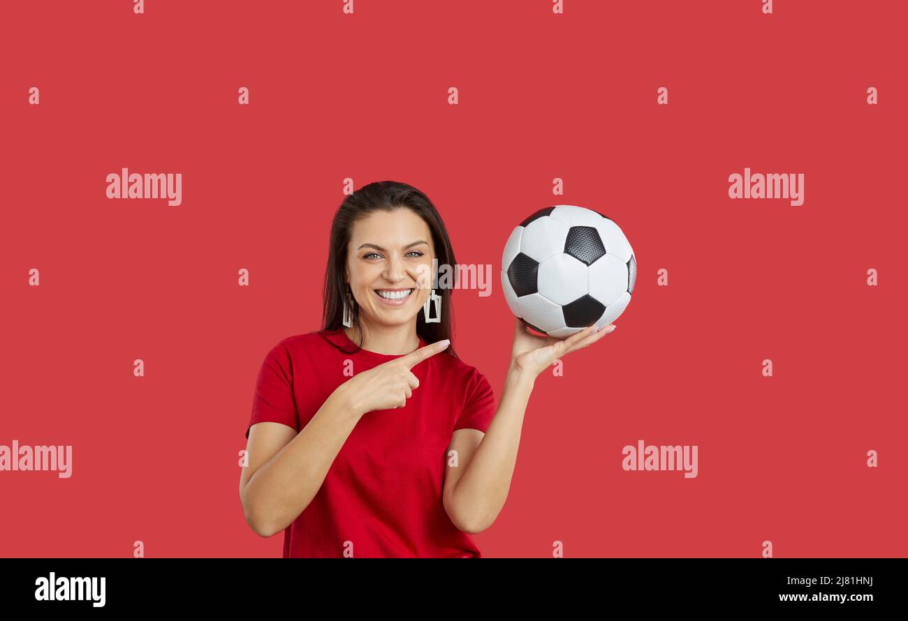 Smiling woman point at football ball Stock Photo