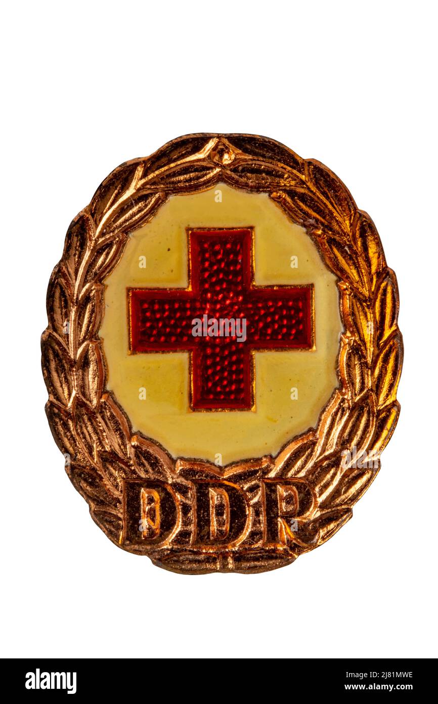 Potsdam, Germany - MAY 06, 2022. Badges, orders and medals from GDR (DDR). Close-up of a National Defence Badge of the German Red Cross in bronze. Cli Stock Photo