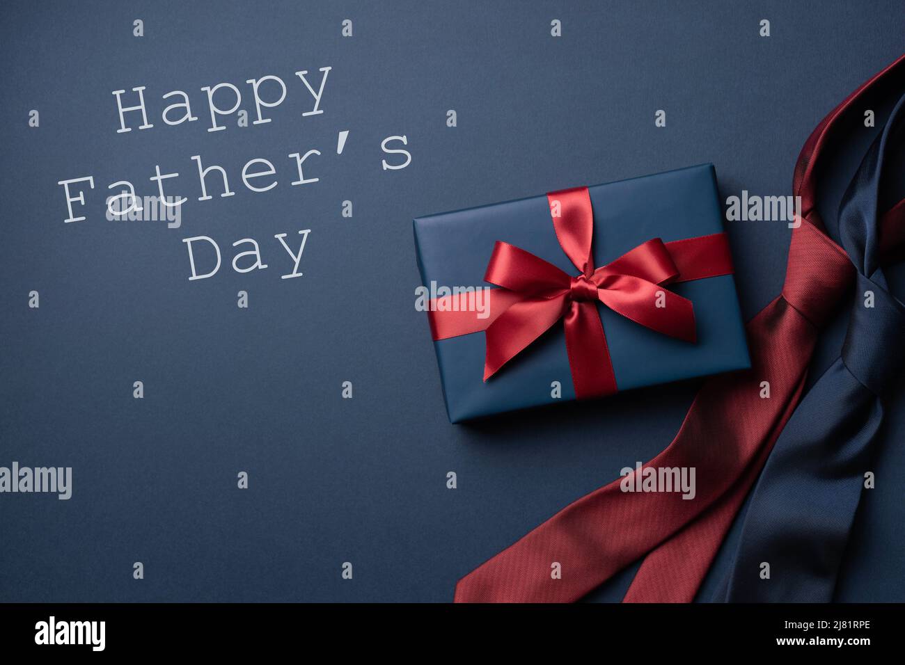 Blue gift box and neckties on dark blue background. Father's day card. Stock Photo