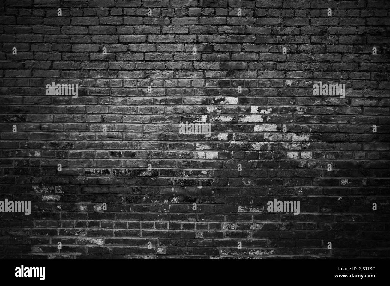 Black brick wall with top illumination effect. Background photo texture Stock Photo