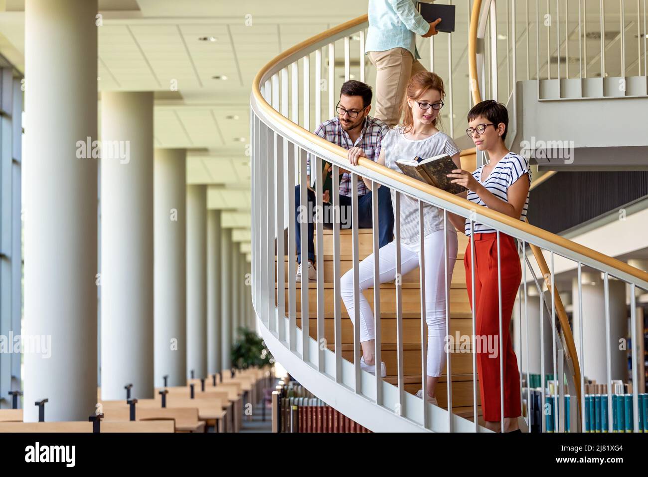 Happy group of students studying and working together in a college library Stock Photo