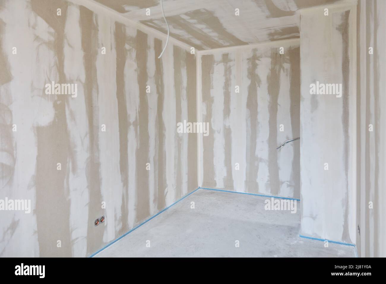 Filler work on the wall and ceiling in a room with a corner in the new building Stock Photo