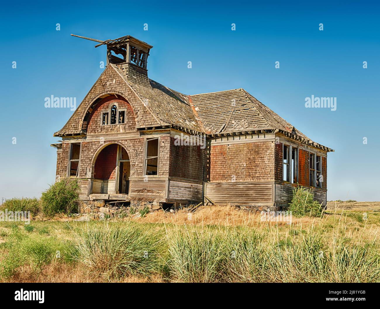The old schoolhouse stands empty in the fields in the ghost town of Govan, Washington. The town is the site of several unsolved axe murders. Stock Photo