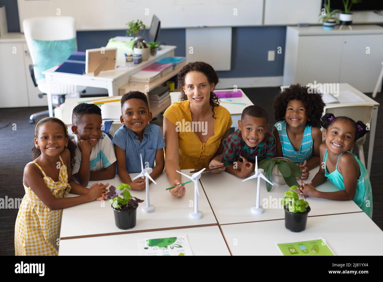Portrait of african american students with caucasian young female teacher with windmill models Stock Photo