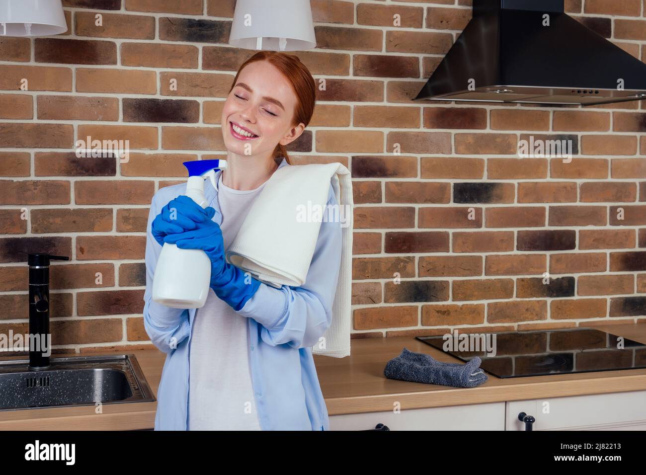 caucasian redhaired ginger housewife in casual clothes and gloves singing kitchen Stock Photo