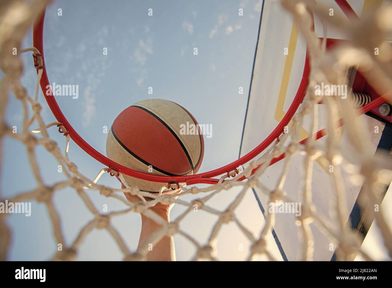 man throwing the ball in hoop. hands and basketball. dunk in basket. slam dunk in motion Stock Photo