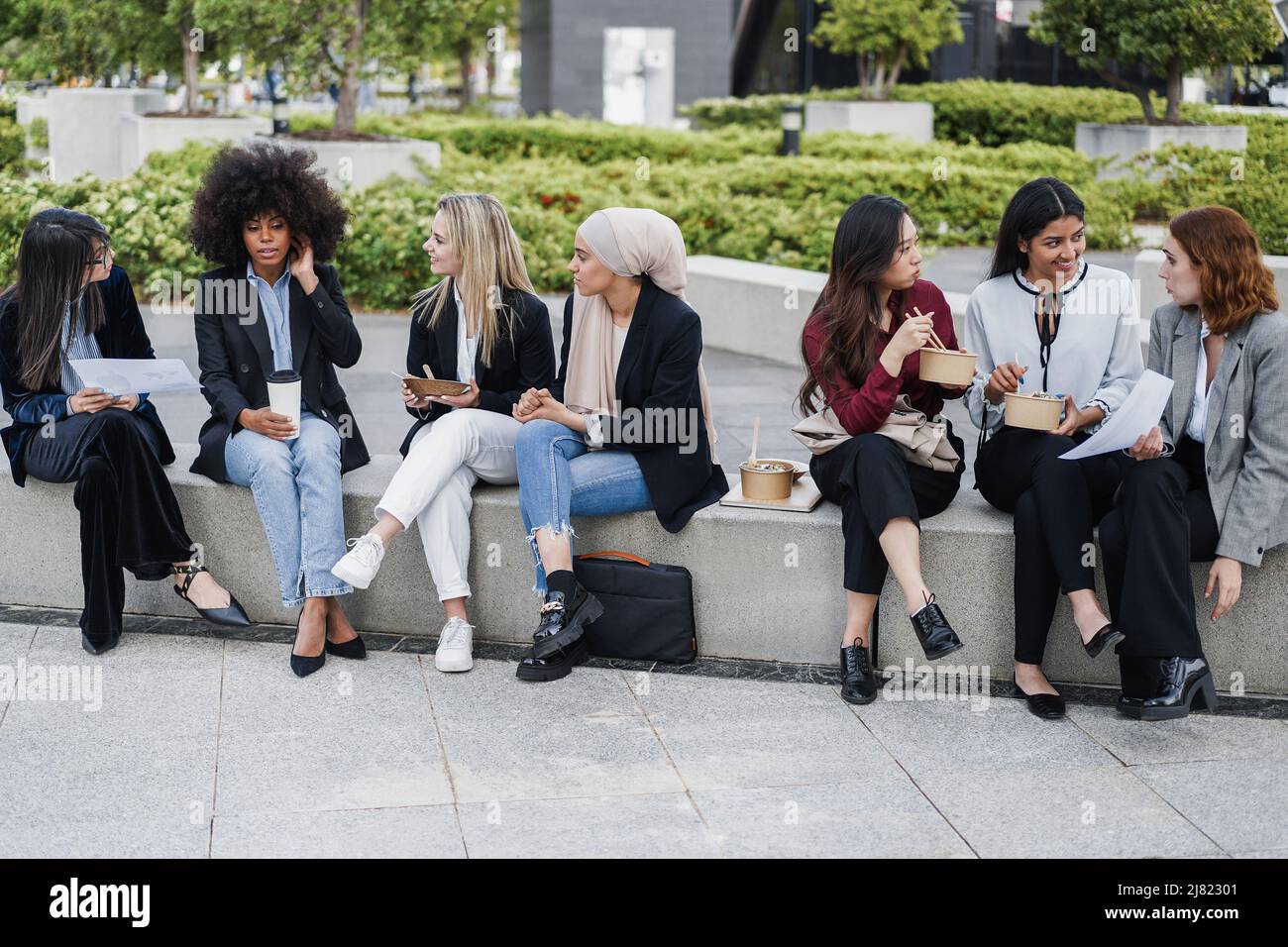 Multiethnic business women doing lunch break outdoor from office building - Focus on muslim girl face Stock Photo