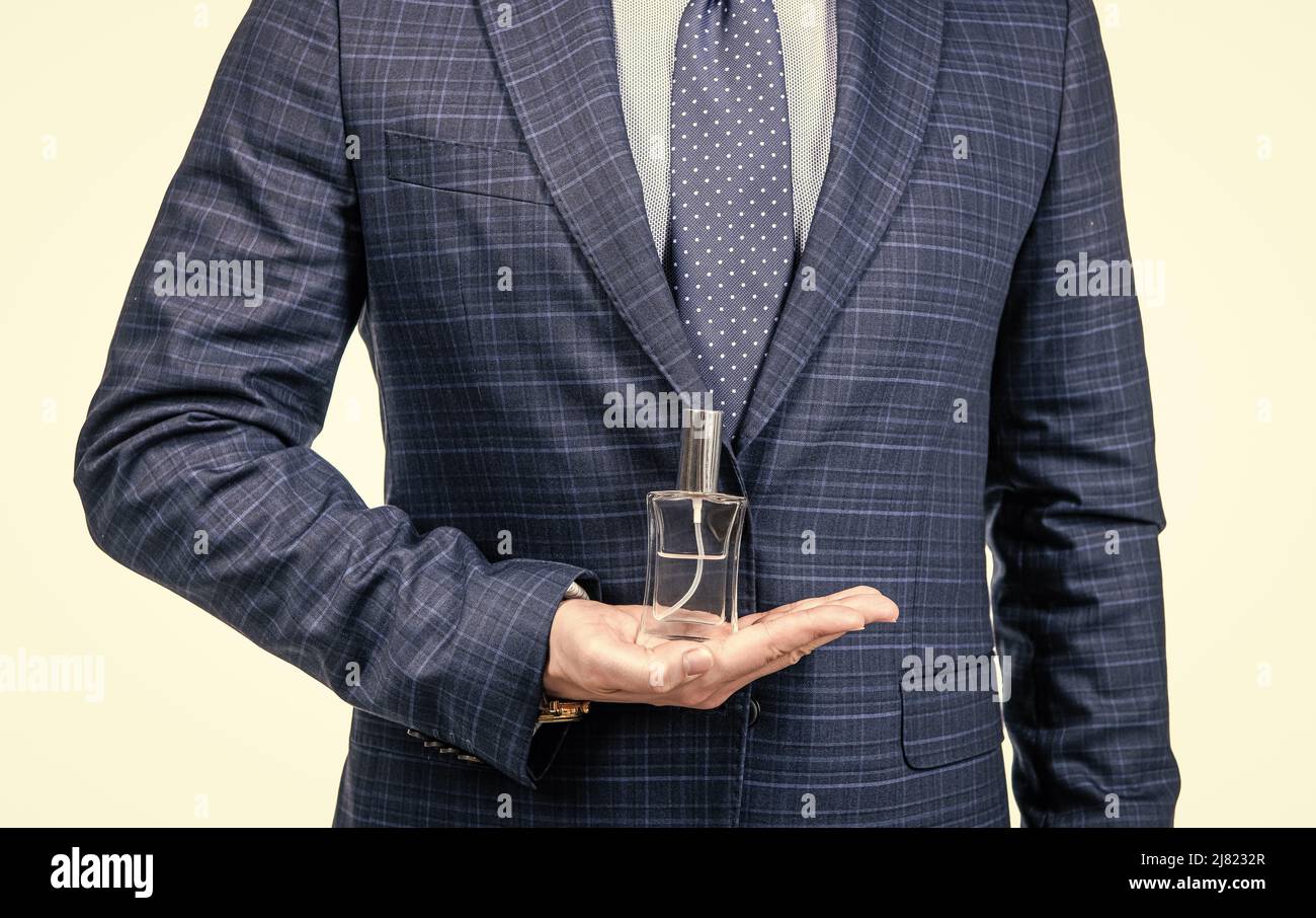 Businessman cropped view hold perfume bottle in open hand isolated on white, fragrance Stock Photo
