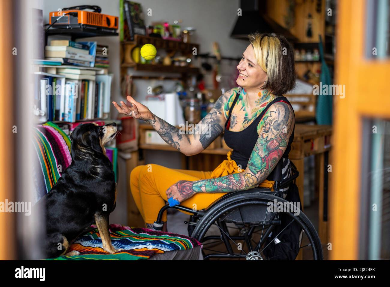 Young woman with disability with her dog at home Stock Photo
